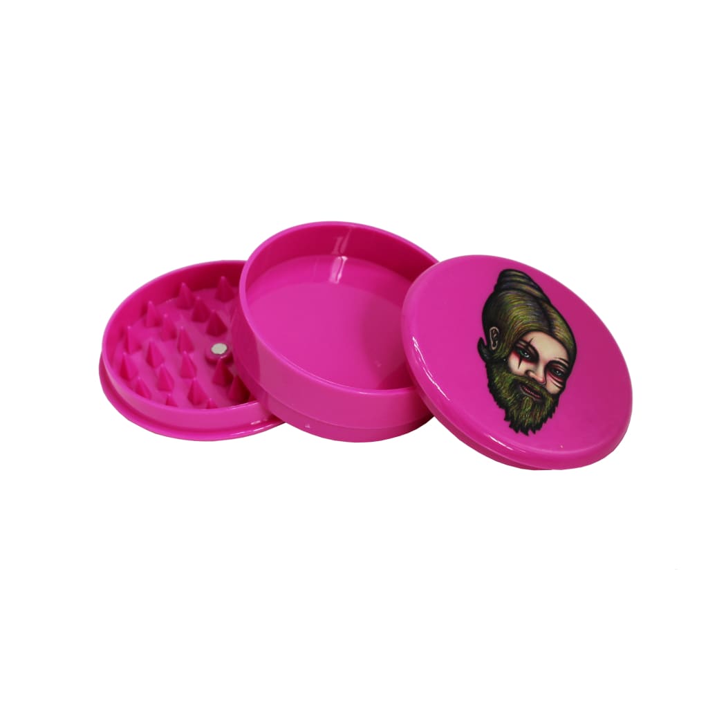 Bright pink plastic herb grinder with bearded face illustration from Coleccionables De Picadores