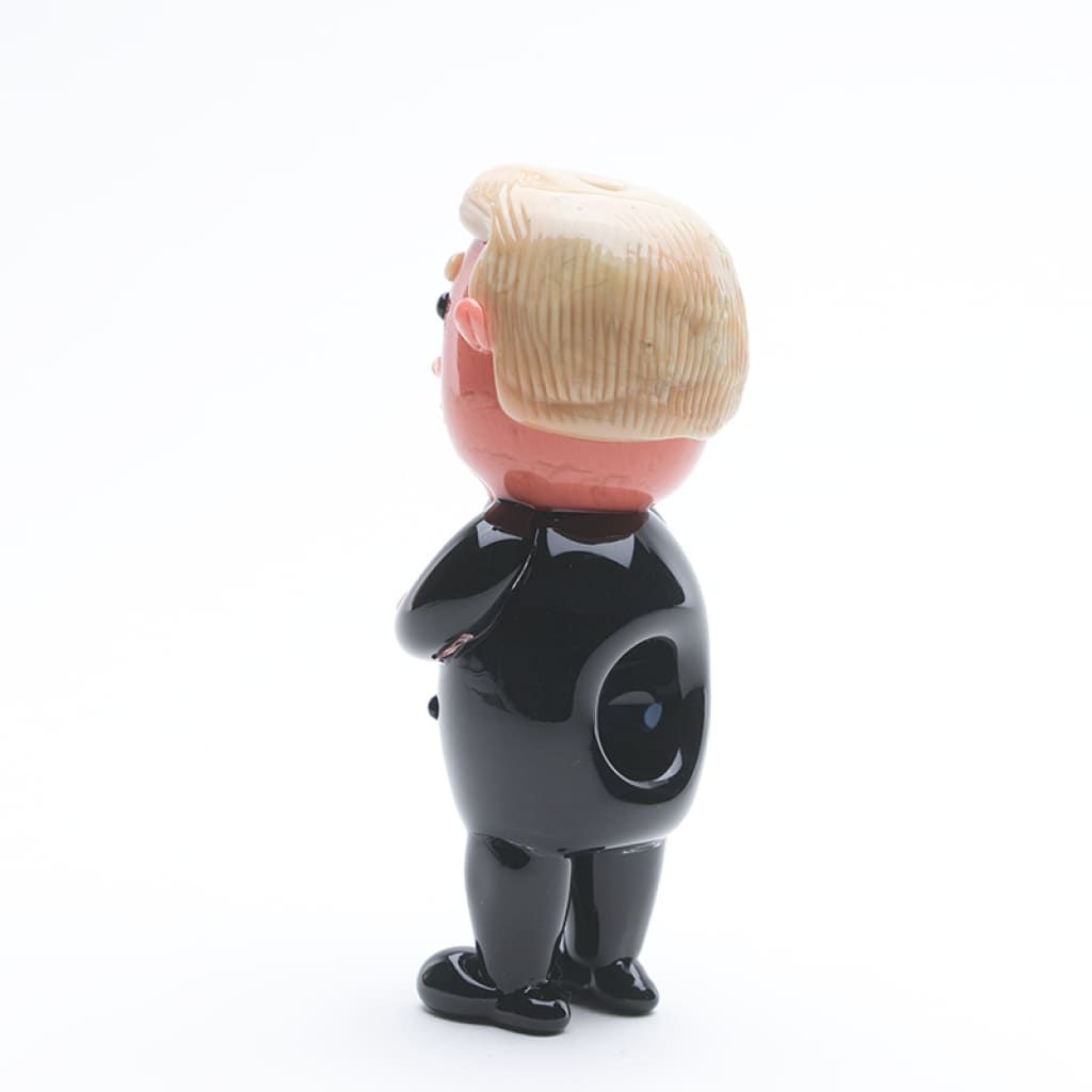 Cartoon-style figurine of a man in a black suit with blonde hair - Empire Glassworks Agent Orange