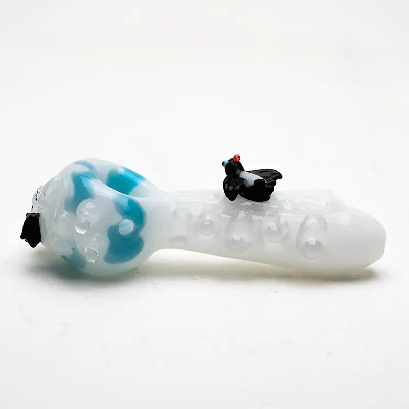 Empire Glassworks Icy Penguins spoon pipe with translucent white glass and skunk figurine