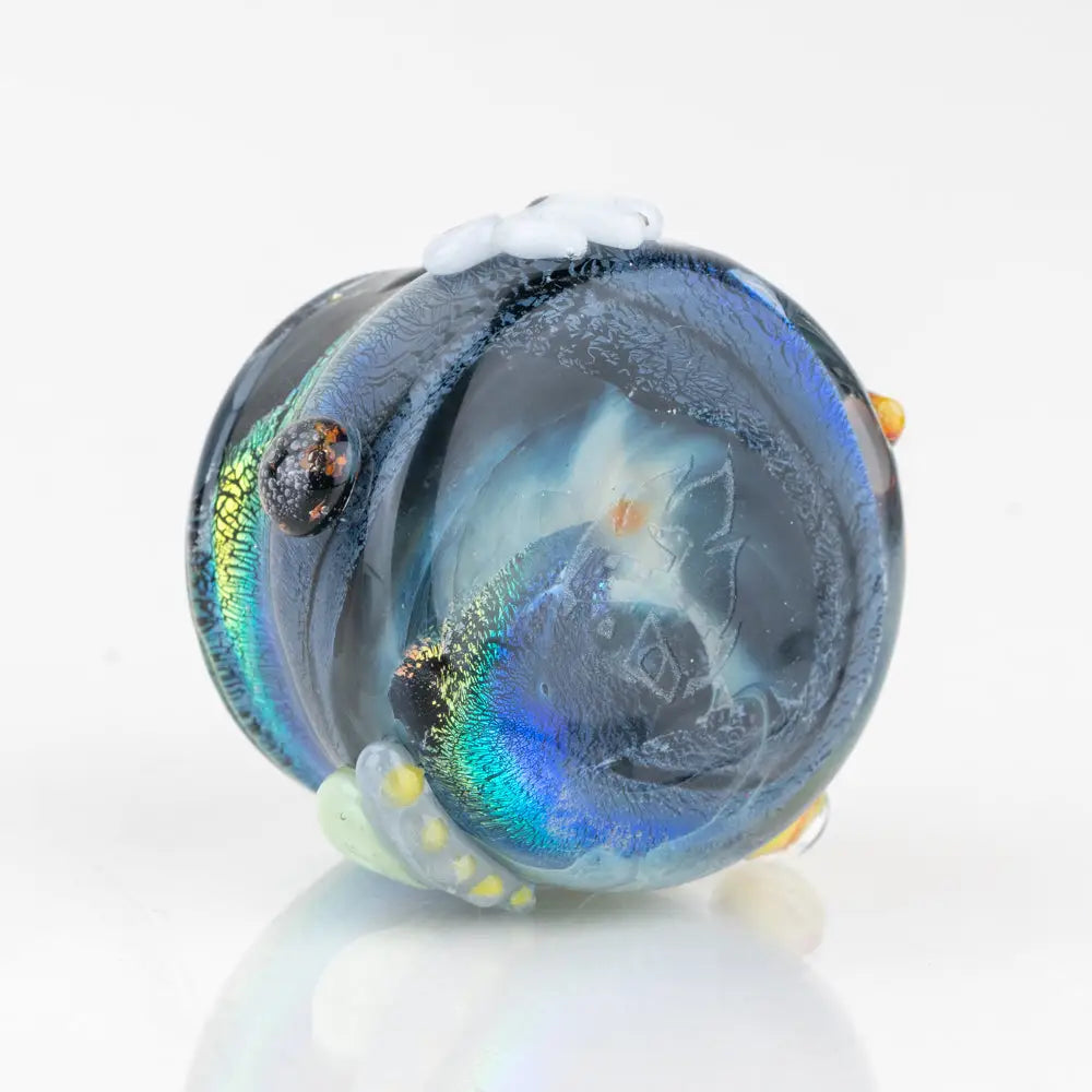 Empire Glassworks terp jar Across the Universe: translucent blue glass figurine with iridescent swirls, black eye, and delicate white floral accents