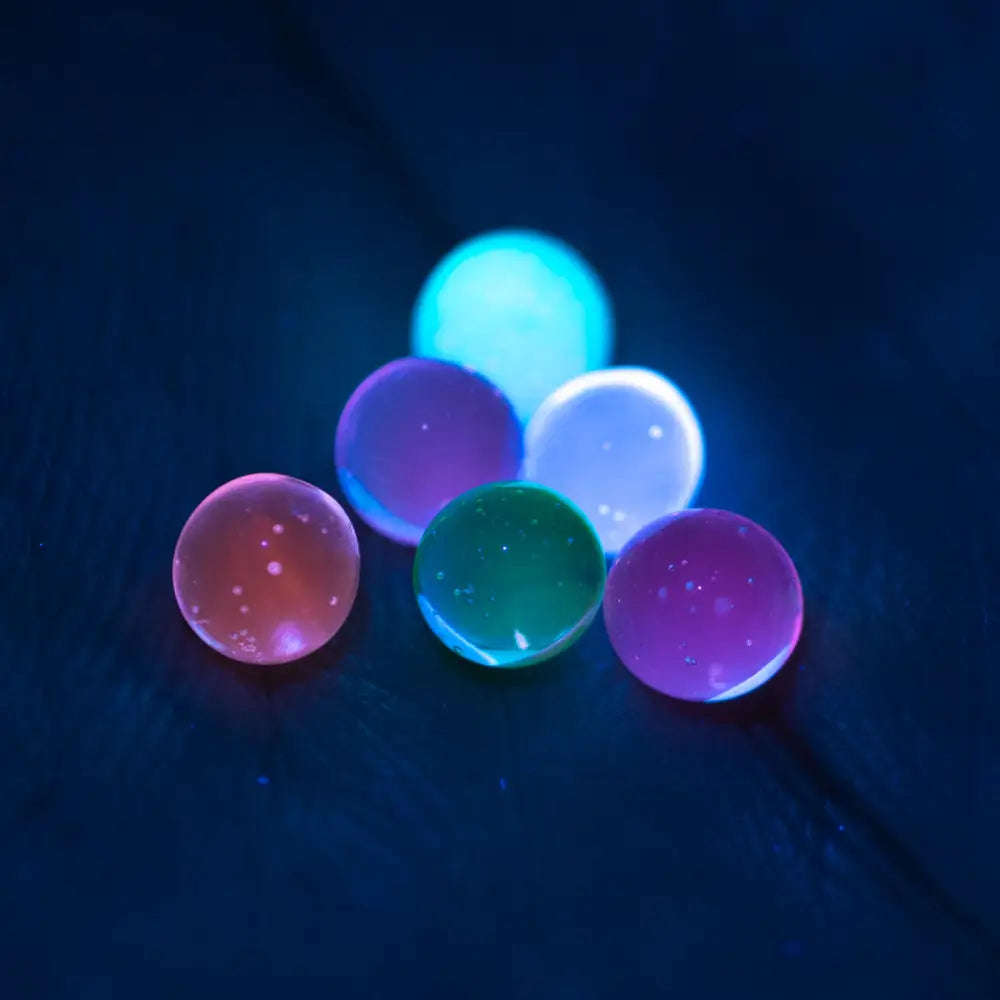 Glowing translucent Empire Glassworks Terp Pearls 4mm UV pearls in pink, purple, teal, blue hues