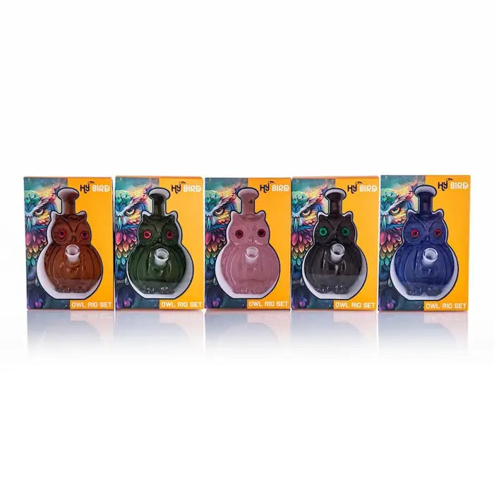 Owl-shaped glass pipes in boxes, part of the Hybird Owl Rig collection, vibrant colors