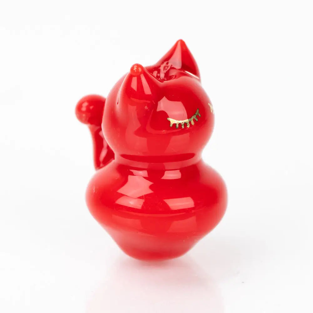 Glossy red Sakibomb Kitty Carb Cap with closed-eye cat figurine