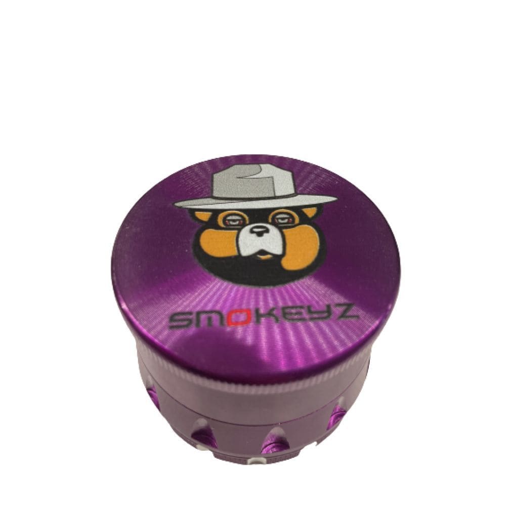 Purple Smokeyz metal grinder with cartoon bear hat and clear lid