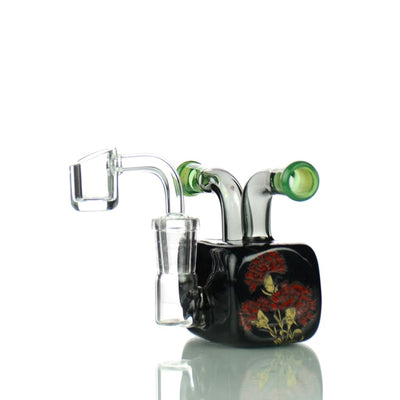 Glass dab rig with floral designs and a black base featuring a 14mm male banger