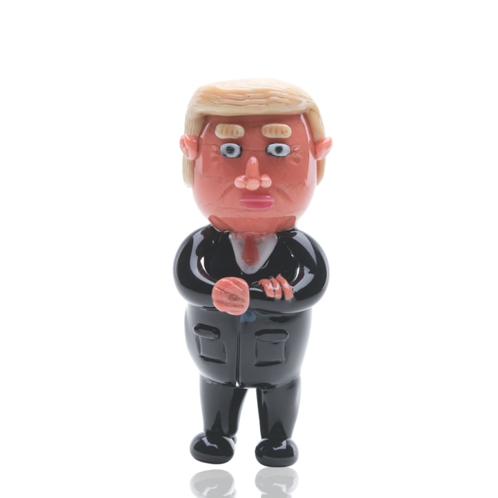 Empire Glassworks Agent Orange cartoon-style figurine with black suit and blonde hair