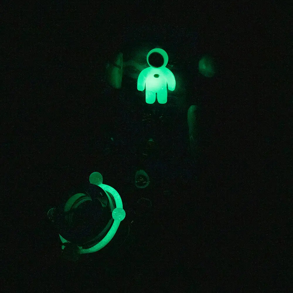 Glowing green astronaut charm on Empire Glassworks Baby Beaker-Galactic Bong