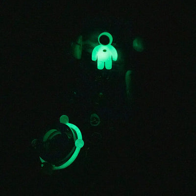 Glowing green astronaut charm on Empire Glassworks Baby Beaker-Galactic Bong