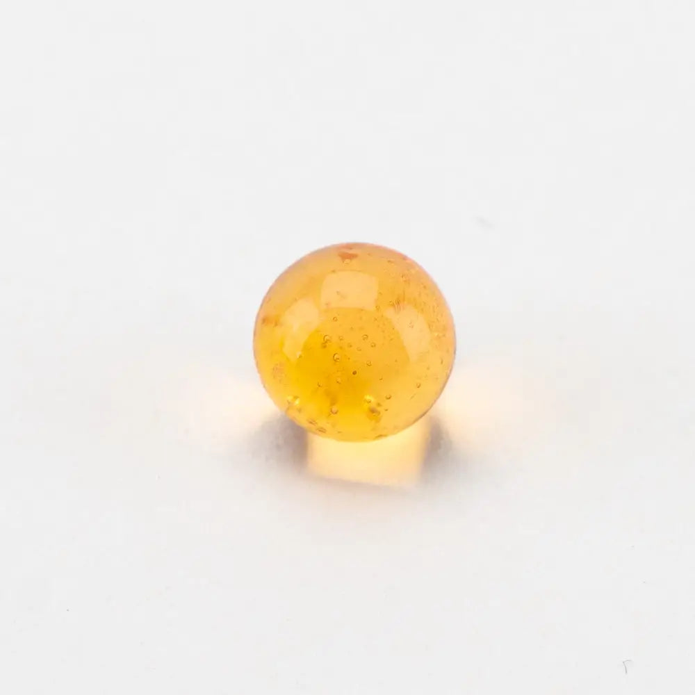 Translucent amber Empire Glassworks dragon sphere spinner carb cap marble