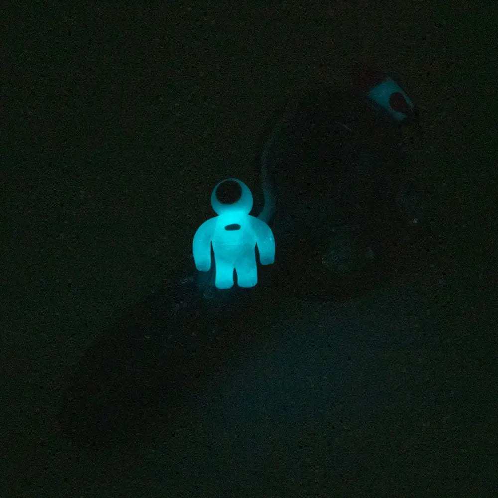 Glowing blue astronaut charm on Empire Glassworks galactic spoon pipe