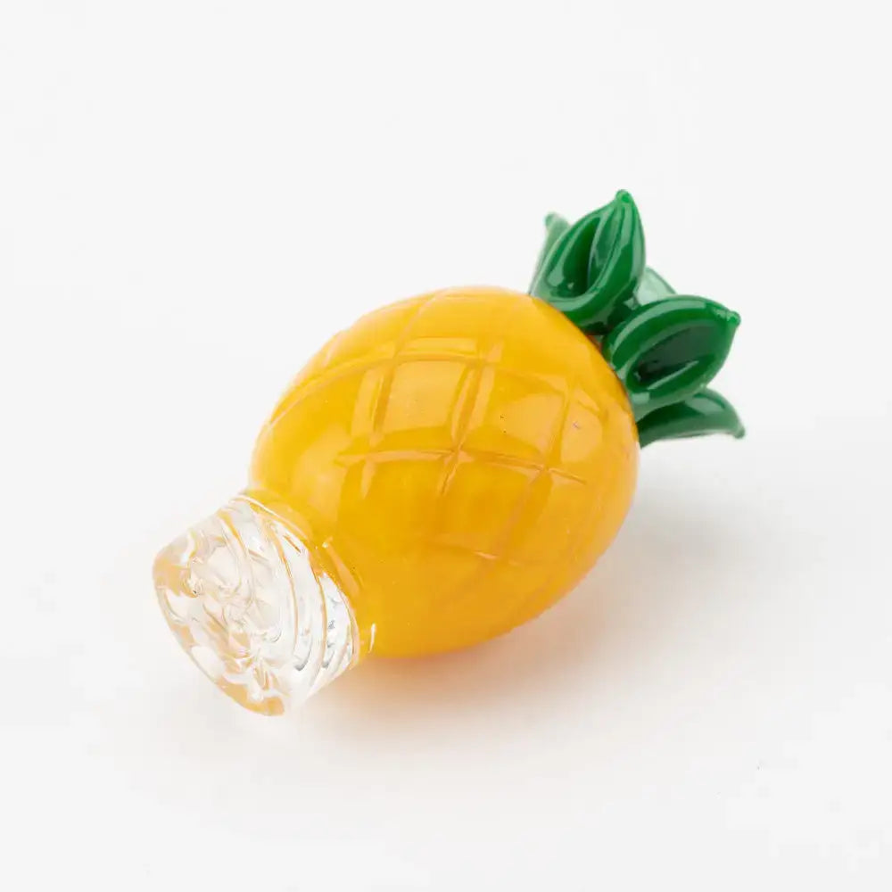 Empire Glassworks pineapple themed carb cap with translucent yellow glass bottle and green leafy top
