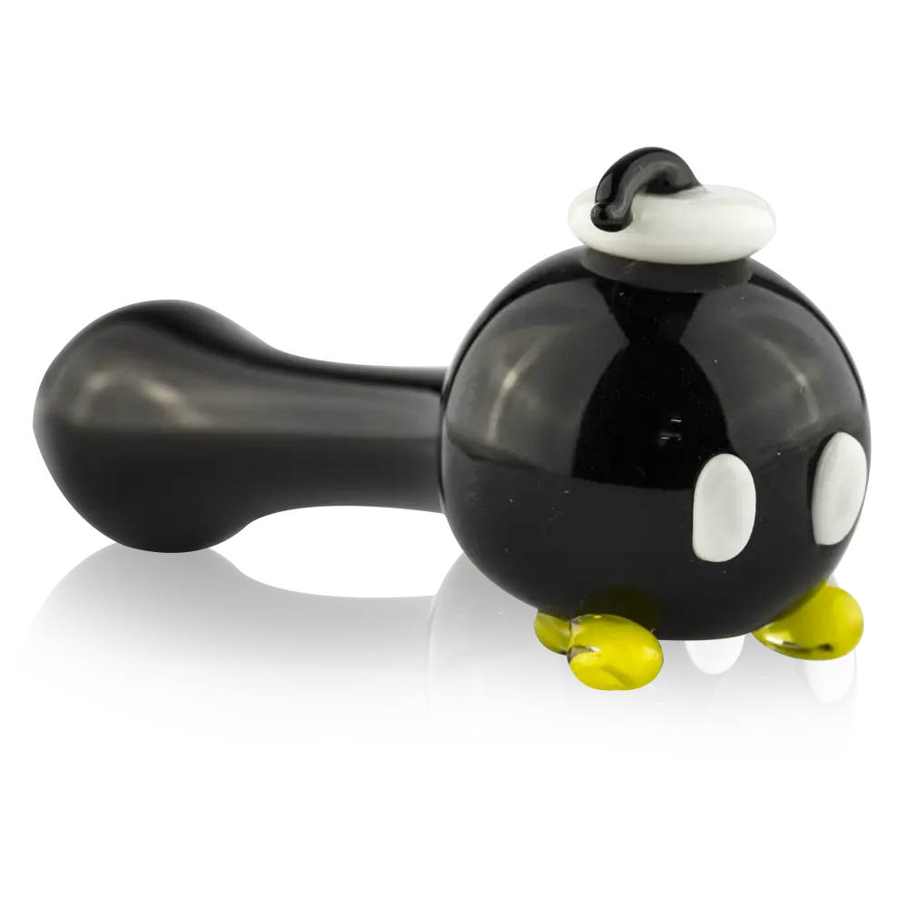 Empire Glassworks spoon pipe: bomb-shaped black glass with white eyes, yellow feet, white fuse