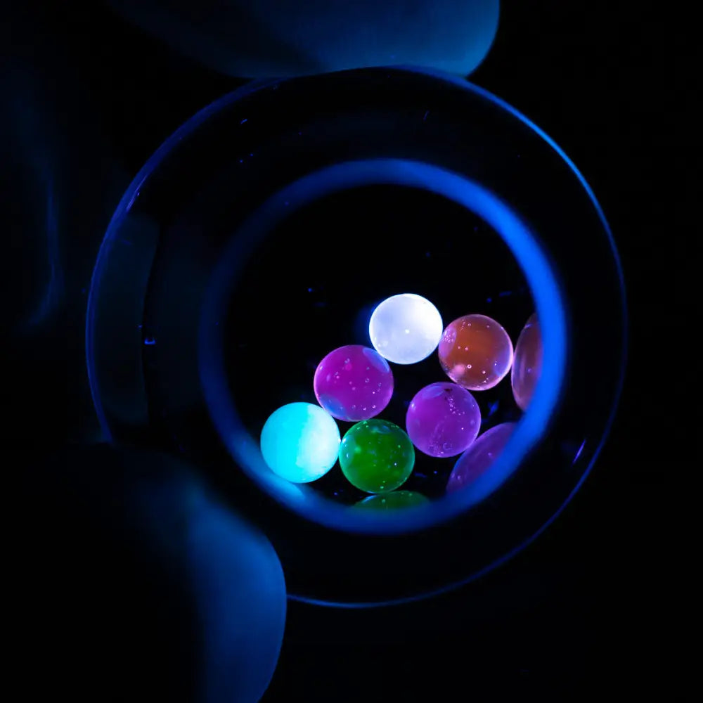 Empire Glassworks 4mm UV Terp Pearls glowing under blacklight