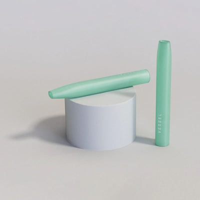 Mint green mascara on white platform with Handcrafted Glass One-Hitter Pipes - 3 Pack