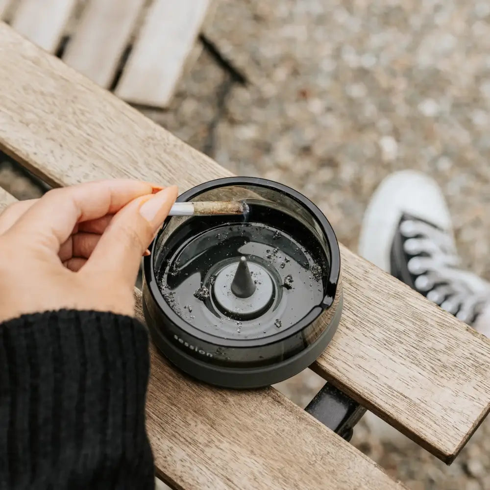Session Goods ashtray: black circular with cone and textured rim on wood