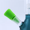 Glass water pipe with green mouthpiece, enhanced by silicone cleaner plugs for optimal use