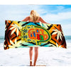 Person holding colorful ’Chill Vibes Weed Beach Towel’ with marijuana leaf designs on a beach