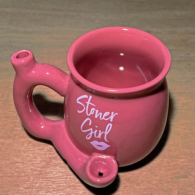 Pink Stoner Girl mug hand pipe: A pink ceramic mug with ’Stoner Girl’ text and a built-in pipe