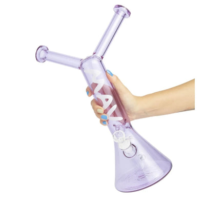 Hand holding mav glass piece with cross neck and conical base, paired with dope art tees