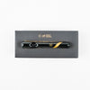 Sleek black vaporizer pen on Marley smoked glass steamroller box with gold stripe design