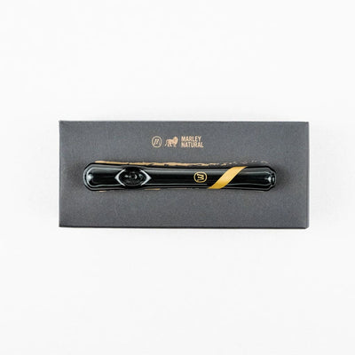 Sleek black vaporizer pen on Marley smoked glass steamroller box with gold stripe design