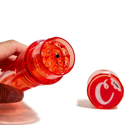 Red plastic herb grinder with transparent top, perfect for consistent pre-roller cone filling