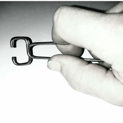 Stainless steel roach clip held by thumb and forefinger