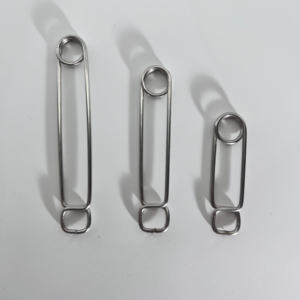 Three stainless steel roach clips of varying lengths in descending order