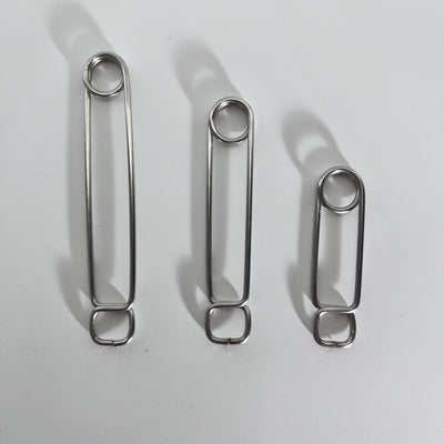 Three stainless steel roach clips of varying lengths in descending order