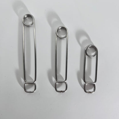 Three stainless steel roach clips of varying lengths in descending order