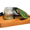 Glass jar with marijuana buds and grinder, ideal for dry herb packaging in resealable zipper bags