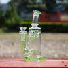 Glass water pipe with intricate percolator, green accents, and 14mm male quartz banger